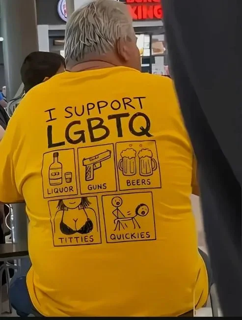 Me too. Person wearing a yellow shirt with crude icons and text making offensive jokes about LGBTQ support. Text: I SUPPORT / LGBTQ / LIQUOR / GUNS / BEERS / TITTIES / QUICKIES