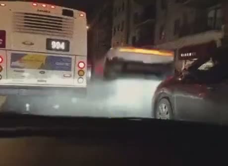 Night scene showing a bus with heavy smoke or steam coming from its…