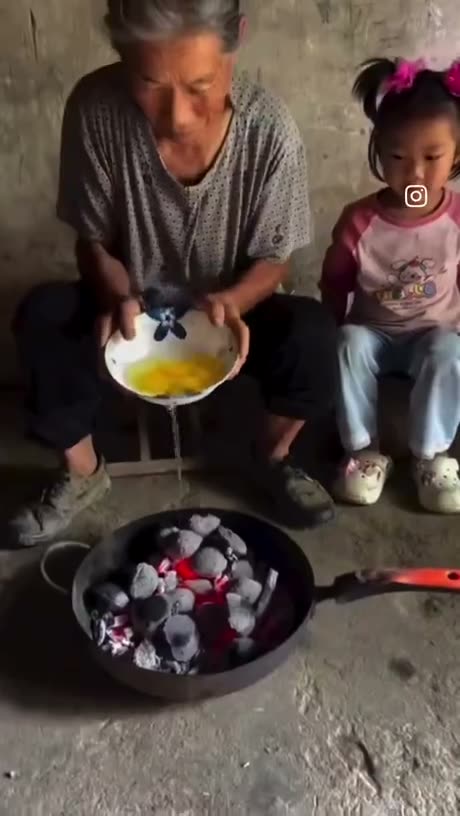 An adult and child cooking together, pouring egg into a pan with red…