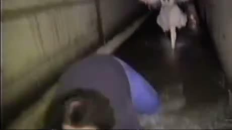 Low-quality video frame showing a person in blue clothing in what…