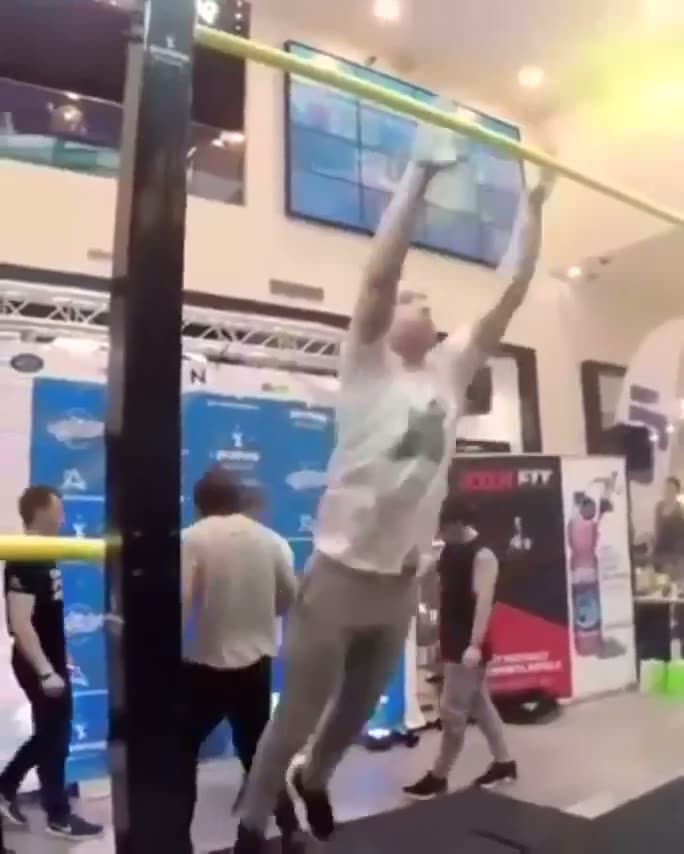Person in white clothing attempting to touch or reach a high…