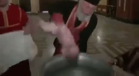 Person in pink outfit jumping or falling into a large bowl of liquid…