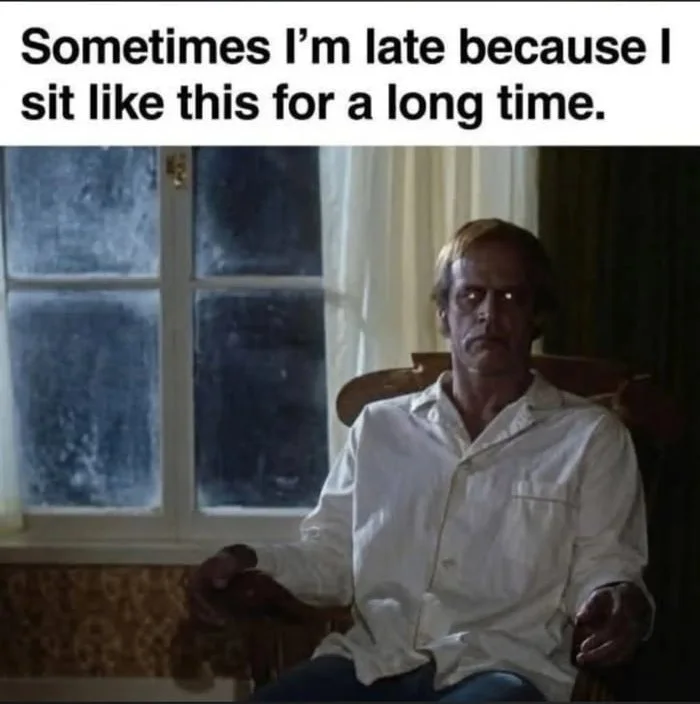 Staring into the void until reality resets. A man sits motionless in a chair staring blankly, illustrating procrastination and losing track of time. Text: Sometimes I'm late because I sit like this for a long time