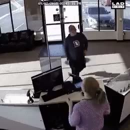 Person entering a building while another person sits at a desk…