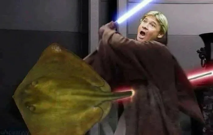 Person wielding a blue lightsaber in a dramatic pose against a large yellow stingray creature