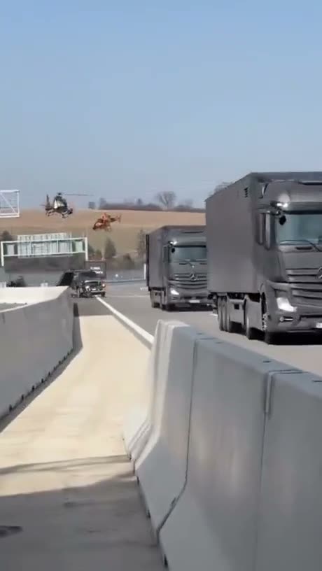 Trucks on a highway with a helicopter hovering in the background…