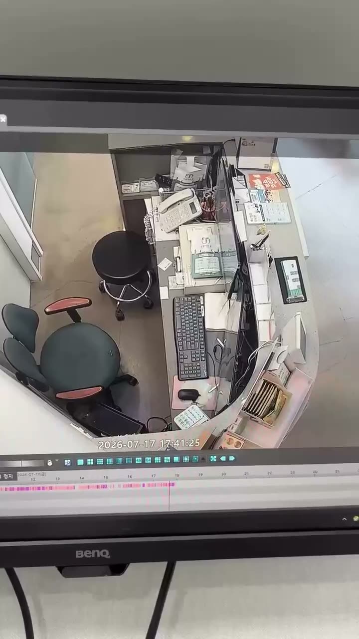 Overhead security camera footage of a cluttered office desk with…