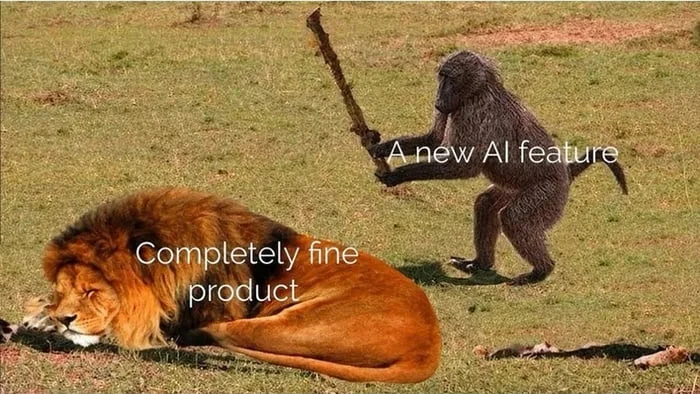 A lion lies still while a chimpanzee swings a stick above it, depicting a product versus new feature. Text: Completely fine product / A new AI feature