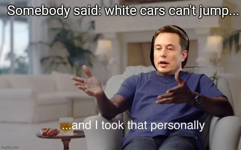 Man in blue shirt gestures expressively while sitting on a couch, appearing offended by a statement. Text: Somebody said: white cars can't jump... / ...and I took that personally