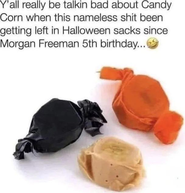 Nobody actually eats these things. Three wrapped candies shown: black, orange, and tan colored, comparing candy corn criticism to other Halloween treats. Text: Y'all really be talkin bad about Candy Corn when this nameless shit been getting left in Halloween sacks since Morgan Freeman 5th birthday