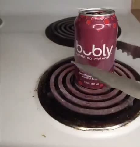 A can of Bubly sparkling water sits on an electric stovetop with…