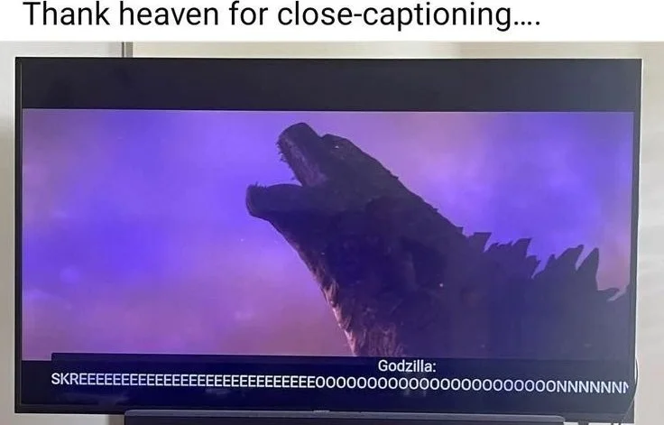 Godzilla roaring with close-caption subtitles showing an exaggerated screech sound. Text: Thank heaven for close-captioning.... / SKREEEEEEEEEEEEEEEEEEEEEEEEEEEOOOOOOOOOOOOOOOOOOOOONNNNNNNN / Godzilla:
