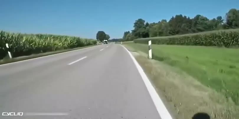 Dashcam view of a straight highway through rural farmland with…