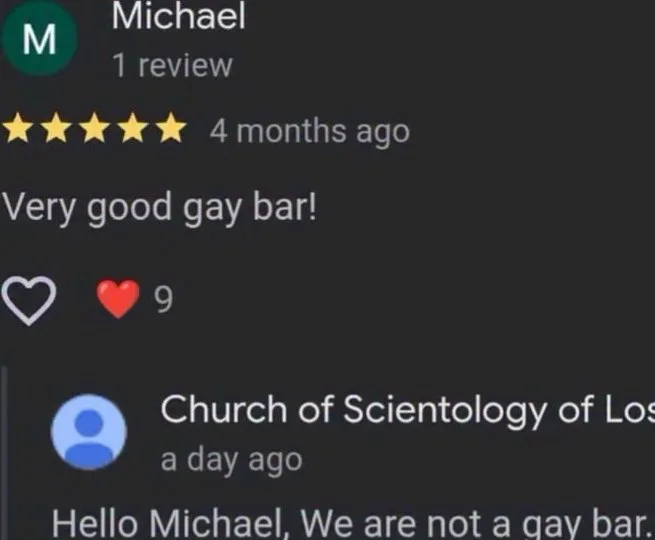 A Church of Scientology account responds to a five-star review calling their location a gay bar, correcting the reviewer. Text: Michael / 1 review / ★★★★★ 4 months ago / Very good gay bar! / ❤️ 9 / Church of Scientology of Los / a day ago / Hello Michael, We are not a gay bar