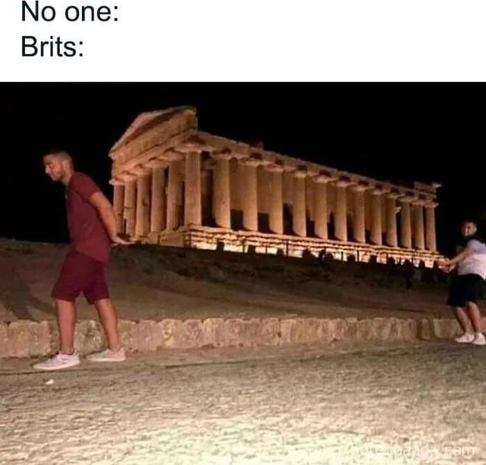 Two people pose with an ancient Greek temple between them as if carrying it. Text: No one: / Brits: