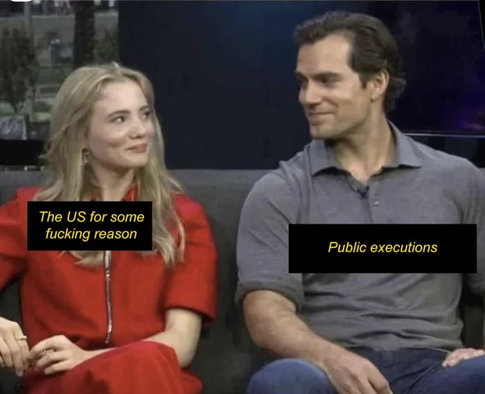 Wait, the US still does that?. Two people sitting on a couch during an interview, with contrasting captions about US policy and public executions. Text: The US for some fucking reason / Public executions