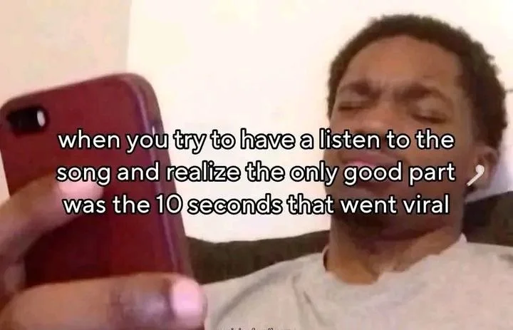 Person holding phone with disappointed expression, representing disappointment when a viral song clip is better than the full song. Text: when you try to have a listen to the song and realize the only good part was the 10 seconds that went viral