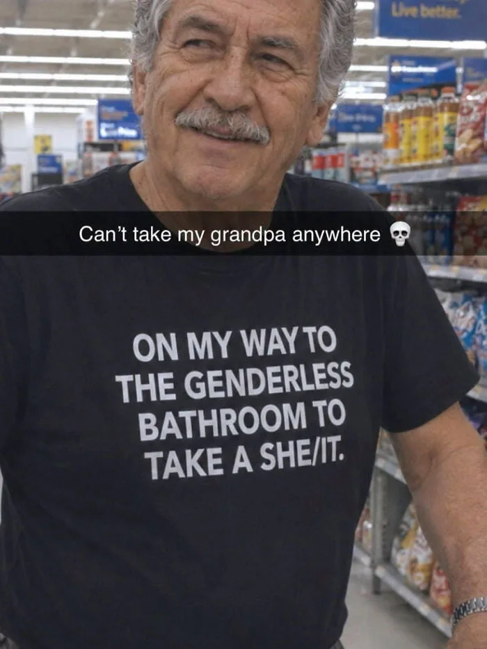 Grandpa's bathroom break goals. An older man wearing a provocative t-shirt with text about genderless bathrooms, photographed in a store. Text: Can't take my grandpa anywhere 💀 / ON MY WAY TO THE GENDERLESS BATHROOM TO TAKE A SHE/IT