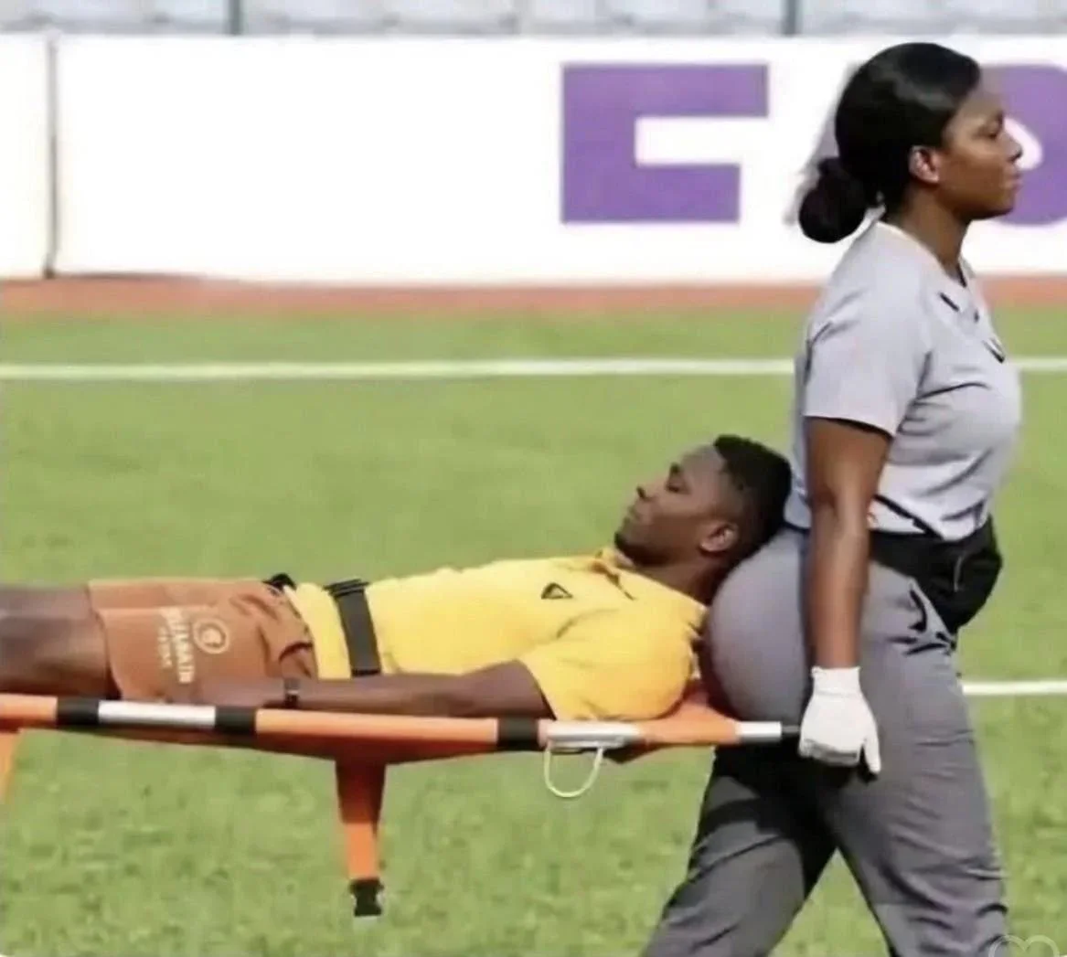 Medical personnel carries an injured athlete on a stretcher during a sports event