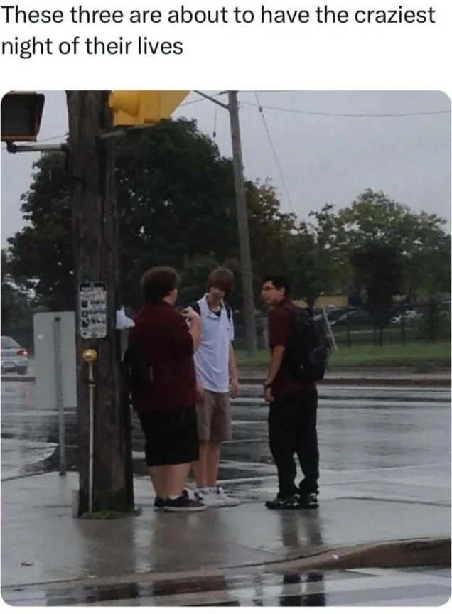 Looks like a legendary night about to unfold. Three young men stand on a wet street corner at dusk, appearing to be having a conversation. Text: These three are about to have the craziest night of their lives
