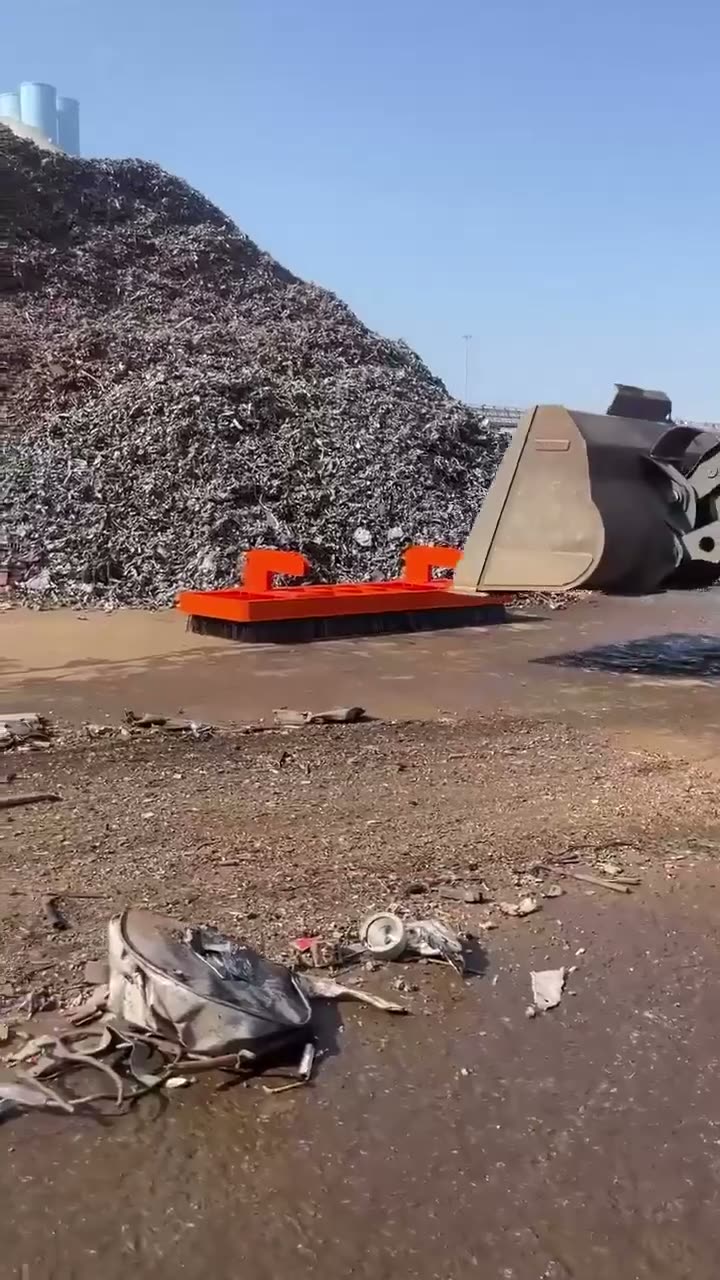Industrial recycling facility with large pile of shredded metal…